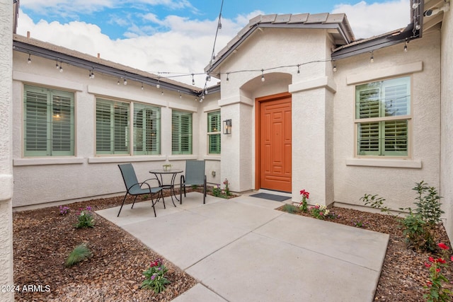 view of exterior entry with a patio area