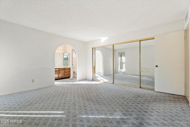 unfurnished bedroom featuring carpet, a closet, and a textured ceiling