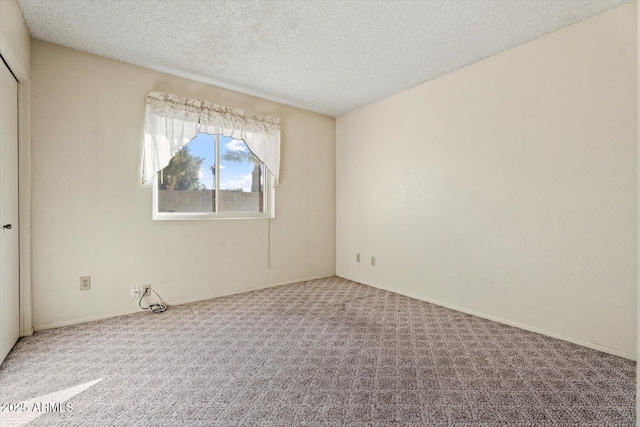 carpeted spare room featuring a textured ceiling