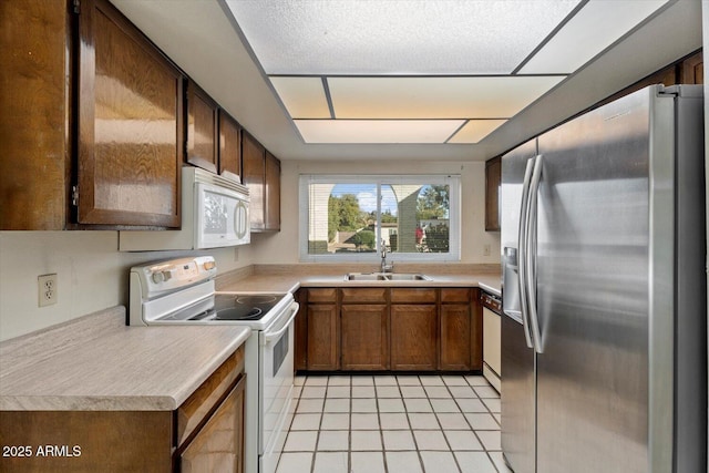 kitchen featuring light tile patterned floors, sink, and white appliances