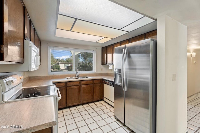 kitchen with light tile patterned floors, sink, and white appliances