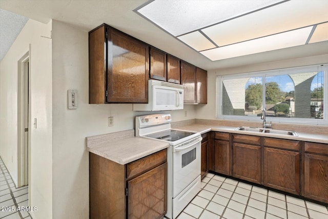 kitchen with sink, white appliances, and light tile patterned floors