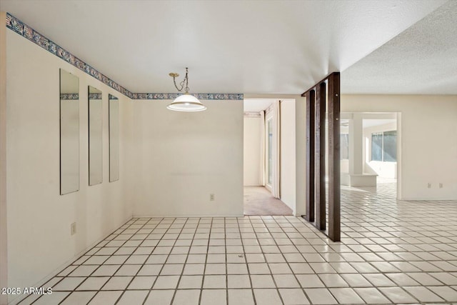 tiled spare room with a textured ceiling