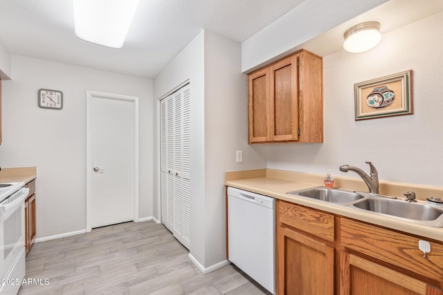 kitchen with sink, white appliances, and light hardwood / wood-style floors