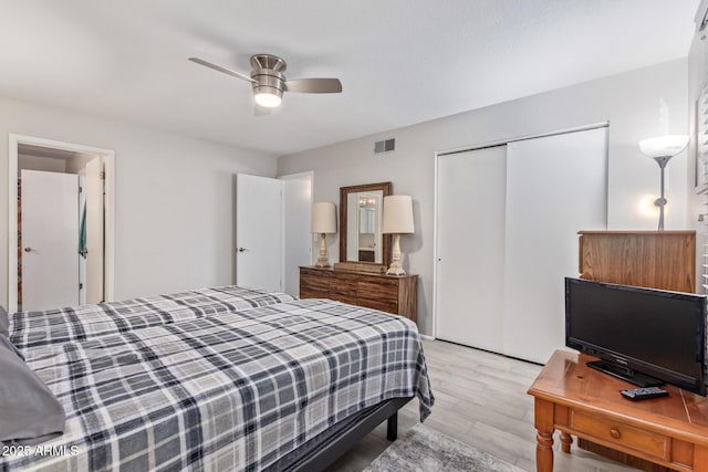 bedroom featuring light hardwood / wood-style flooring, ceiling fan, and a closet