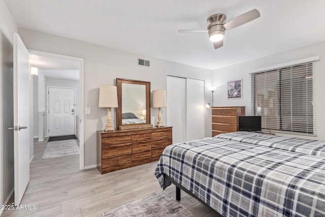 bedroom featuring light hardwood / wood-style flooring, a closet, and ceiling fan