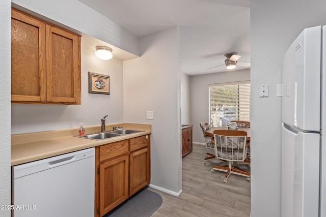 kitchen with ceiling fan, sink, white appliances, and light wood-type flooring