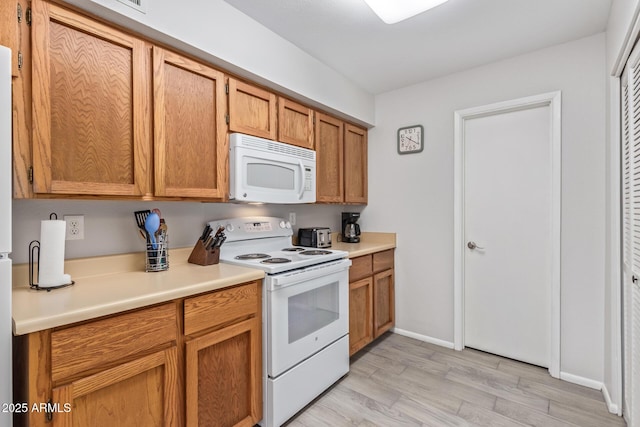 kitchen featuring white appliances and light hardwood / wood-style floors