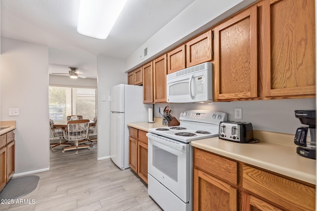 kitchen featuring ceiling fan, white appliances, and light hardwood / wood-style floors