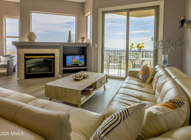 living room featuring a tiled fireplace and light wood-style floors