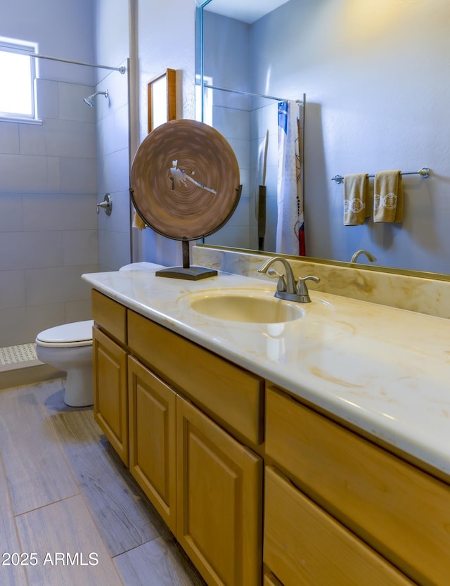 full bath featuring toilet, a shower stall, and vanity