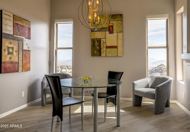 dining room with an inviting chandelier, baseboards, and light wood-style floors