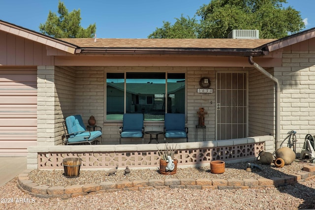 view of exterior entry featuring a porch and a garage