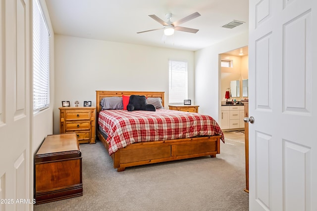 bedroom with visible vents, carpet, ensuite bath, and a ceiling fan