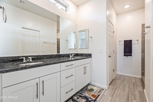 full bathroom with a sink, visible vents, double vanity, and a tile shower