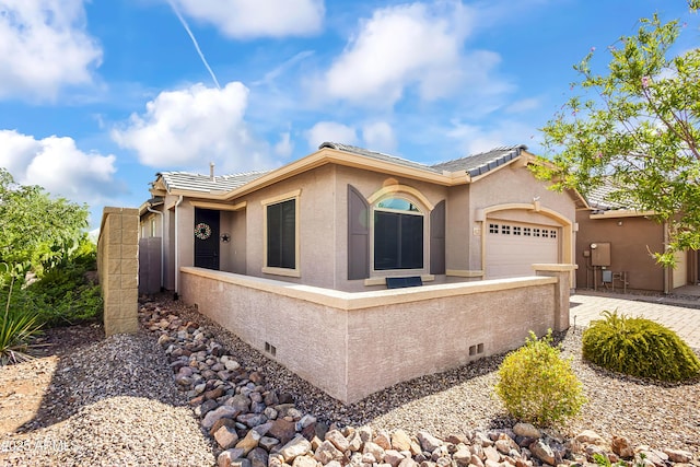 view of front facade featuring a tiled roof, stucco siding, an attached garage, and driveway