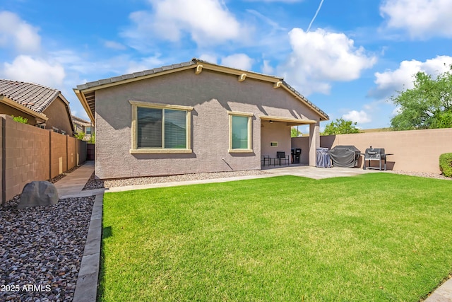 rear view of house featuring stucco siding, a patio, a lawn, and a fenced backyard