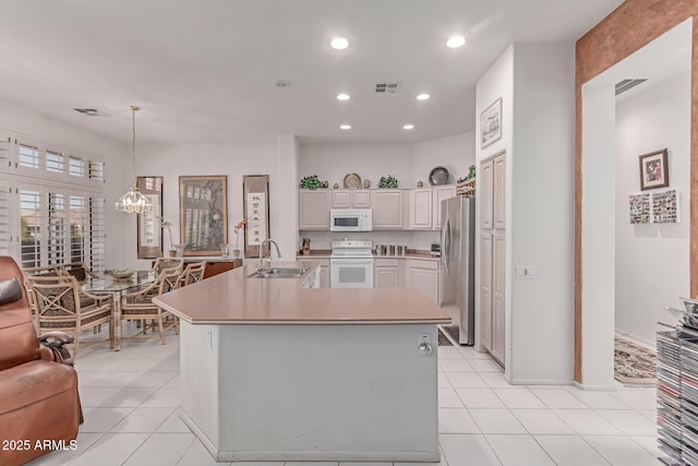 kitchen with a sink, white appliances, light countertops, a chandelier, and light tile patterned floors
