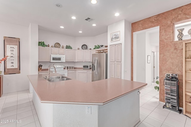 kitchen with visible vents, a sink, light tile patterned floors, and white appliances