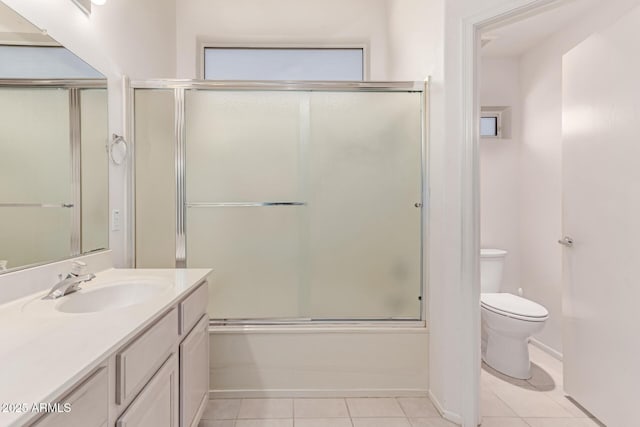 bathroom featuring toilet, tile patterned floors, combined bath / shower with glass door, and vanity