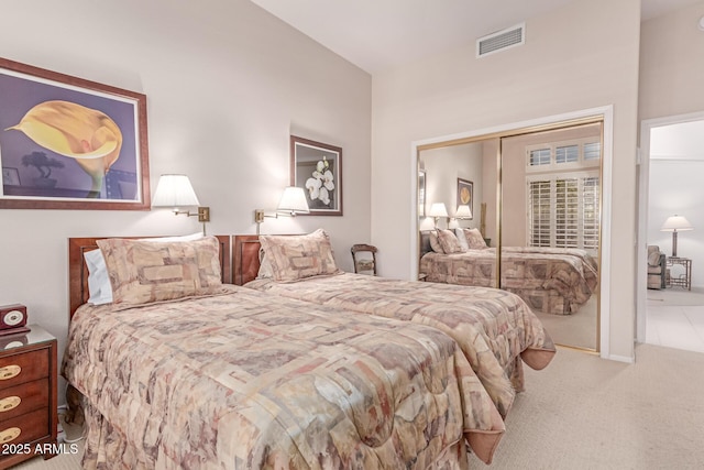 bedroom with carpet floors, visible vents, and a closet