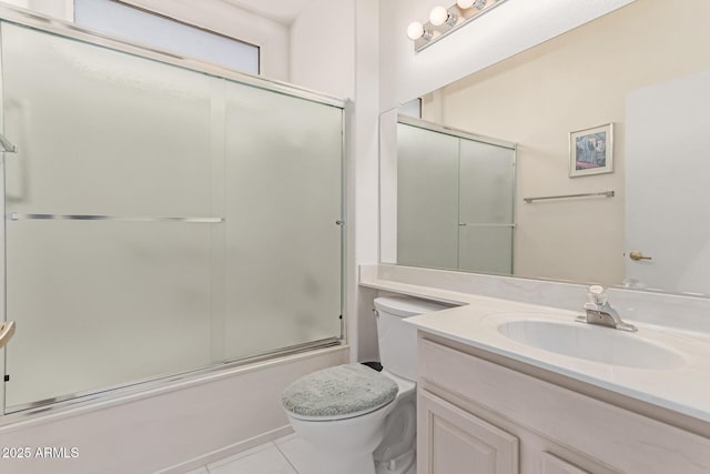 full bath with vanity, bath / shower combo with glass door, tile patterned floors, and toilet