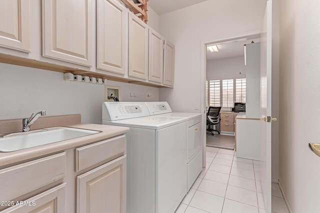 washroom with a sink, light tile patterned floors, cabinet space, and independent washer and dryer