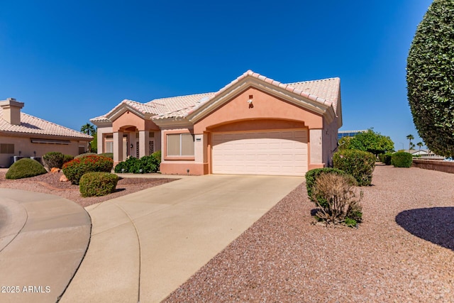 mediterranean / spanish-style house with a garage, stucco siding, concrete driveway, and a tile roof