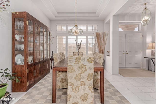 dining area with an inviting chandelier and a tray ceiling