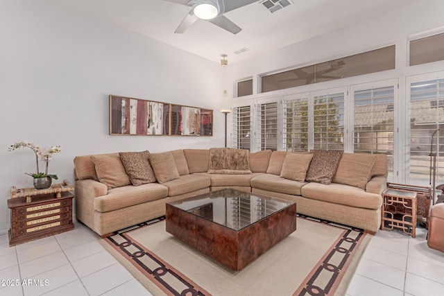 living room with ceiling fan, visible vents, and light tile patterned floors