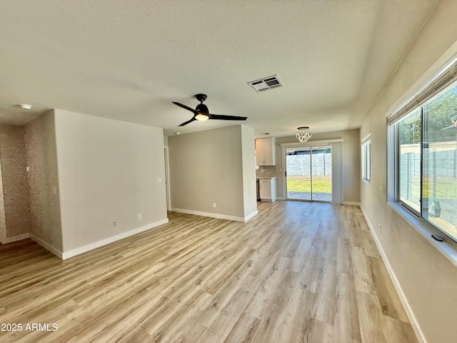 3014 W Zachary Dr, Phoenix, AZ 85027 - unfurnished living room with healthy amount of natural light, light wood-type flooring, a textured ceiling, and a ceiling fan