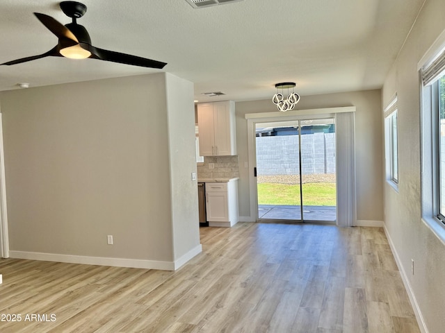 3014 W Zachary Dr, Phoenix, AZ 85027 - unfurnished living room with light wood-style flooring, a ceiling fan, and a chandelier