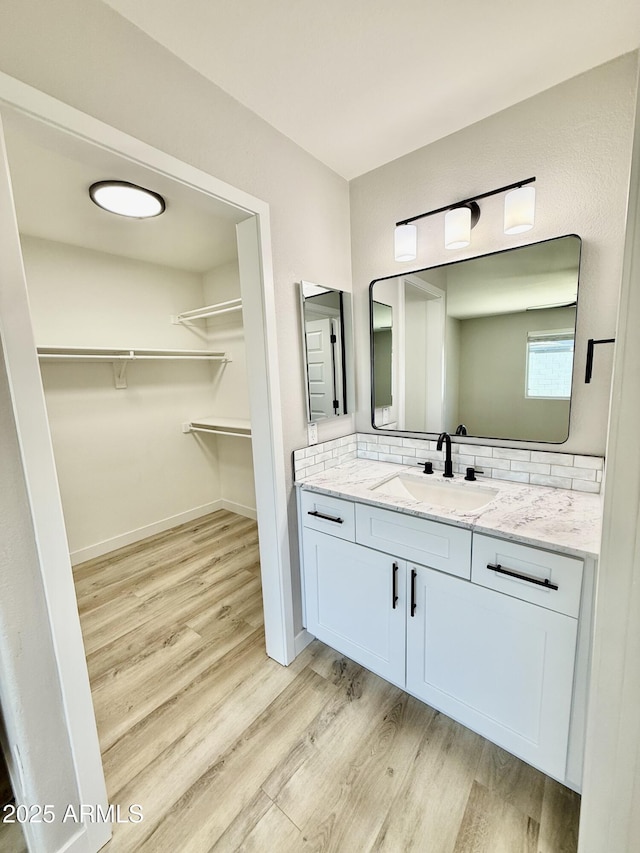 3014 W Zachary Dr, Phoenix, AZ 85027 - bathroom featuring wood finished floors, vanity, backsplash, and a spacious closet