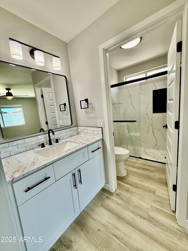 3014 W Zachary Dr, Phoenix, AZ 85027 - full bath with a marble finish shower, vanity, ceiling fan, wood finished floors, and backsplash
