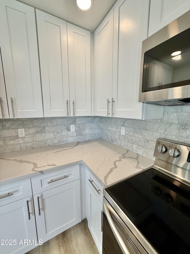 3014 W Zachary Dr, Phoenix, AZ 85027 - kitchen with stainless steel appliances, white cabinetry, and decorative backsplash