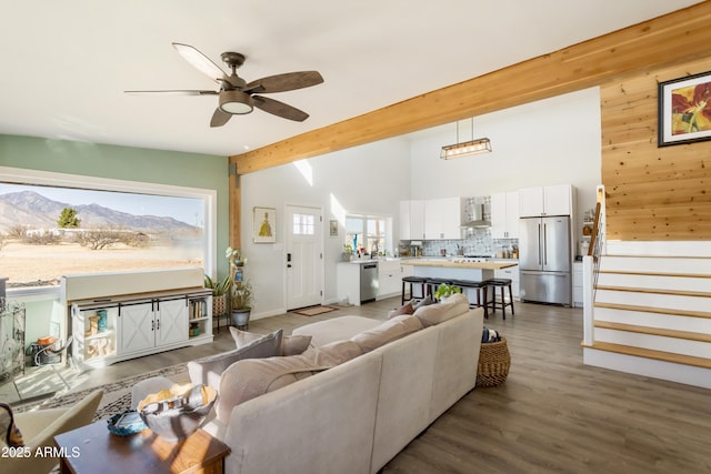 living room with beam ceiling, ceiling fan, high vaulted ceiling, dark hardwood / wood-style floors, and a mountain view