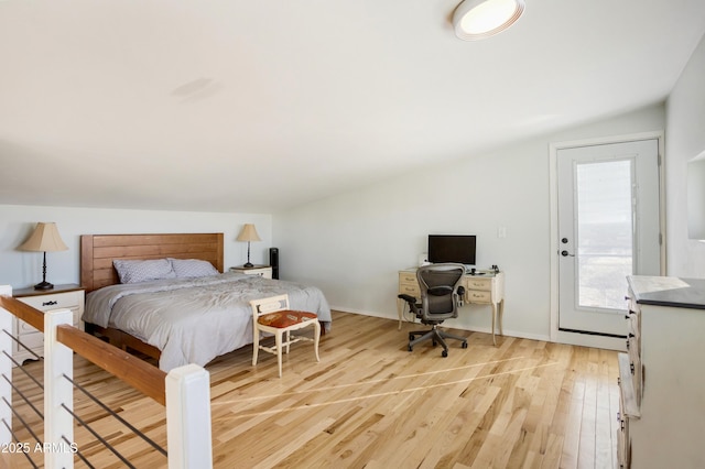 bedroom featuring vaulted ceiling and light wood-type flooring