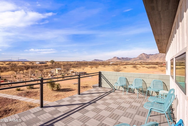 view of patio with a mountain view and a balcony