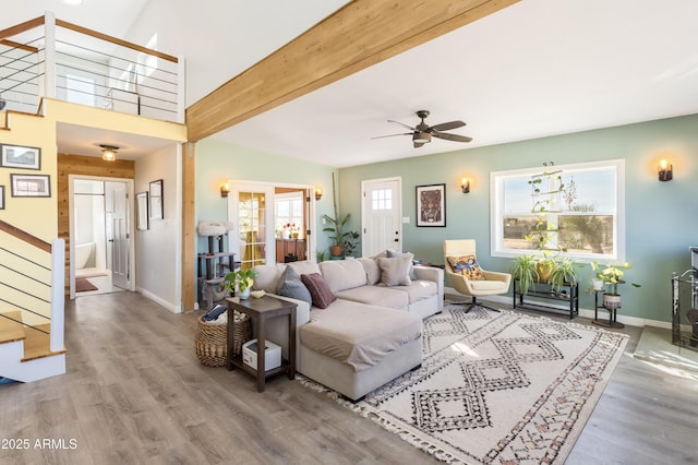 living room with hardwood / wood-style flooring, ceiling fan, and vaulted ceiling with beams