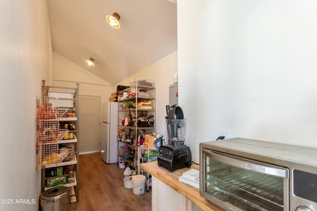 interior space featuring butcher block counters, beverage cooler, dark hardwood / wood-style floors, white refrigerator, and lofted ceiling