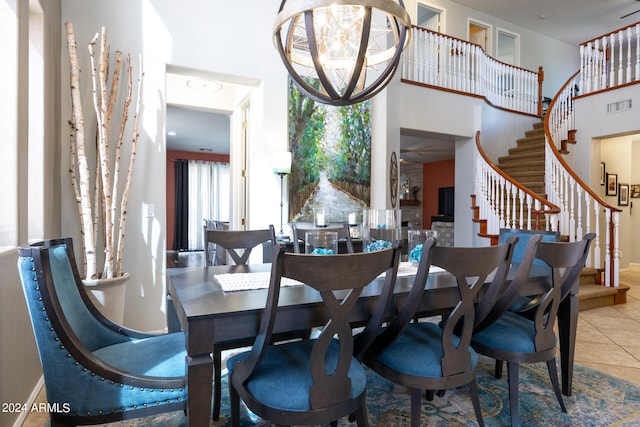 dining room with a high ceiling, a chandelier, and tile patterned floors