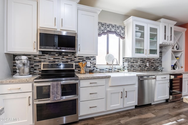 kitchen featuring white cabinets, backsplash, stainless steel appliances, beverage cooler, and dark hardwood / wood-style floors