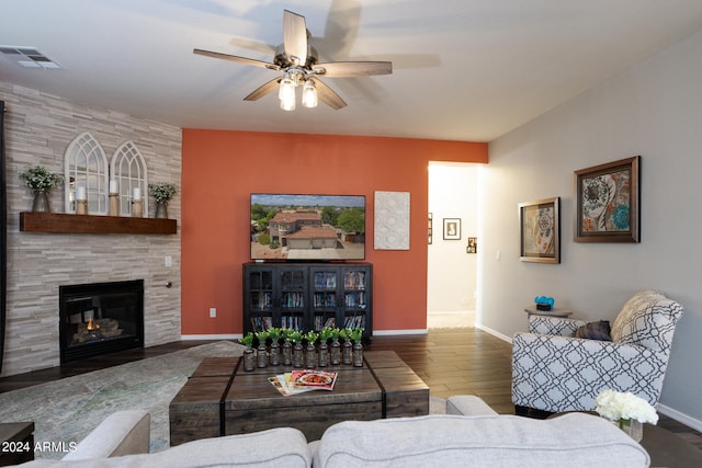 living room with a large fireplace, ceiling fan, and hardwood / wood-style flooring