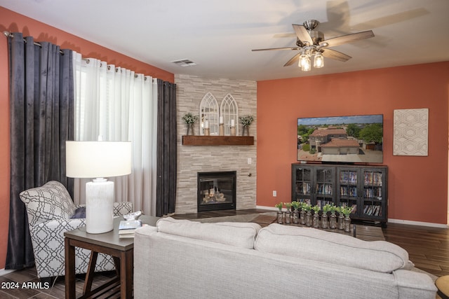 living room featuring ceiling fan, dark hardwood / wood-style flooring, and a large fireplace