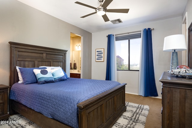 bedroom featuring ceiling fan, light colored carpet, and ensuite bathroom