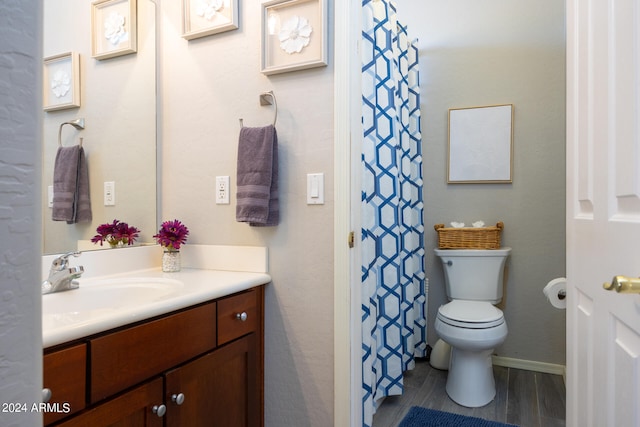 bathroom with vanity, toilet, and hardwood / wood-style flooring