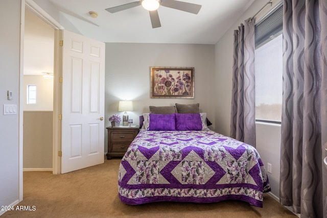 carpeted bedroom featuring multiple windows and ceiling fan