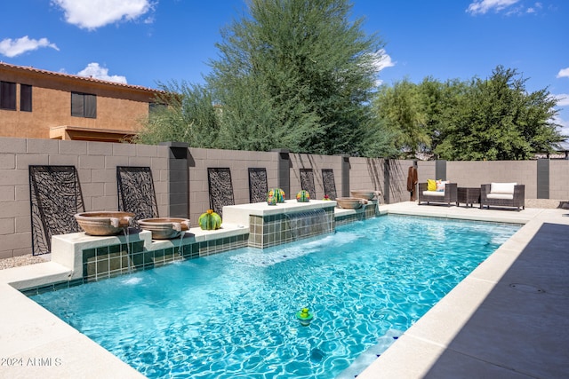 view of swimming pool with pool water feature, a patio, and an outdoor living space