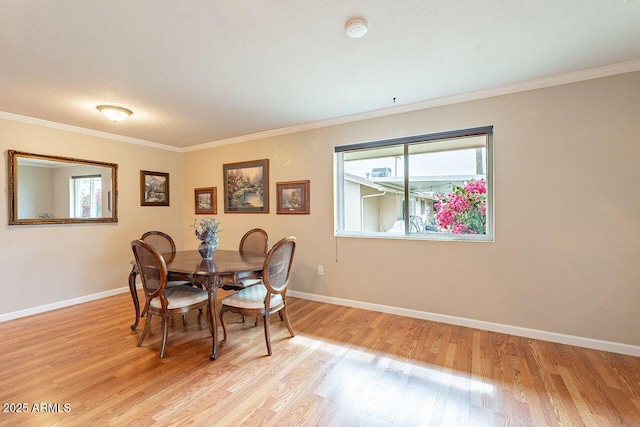 dining room with crown molding and light wood-type flooring