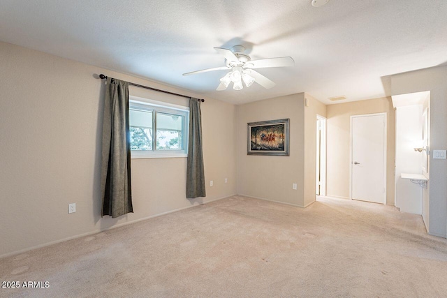 unfurnished room featuring light carpet, a textured ceiling, and ceiling fan